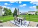 Outdoor dining area with a table, chairs, and umbrella on a patio, surrounded by green lawn at 3811 Tartan Trl, Whitestown, IN 46075