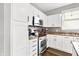 Close-up of a kitchen area featuring stainless steel appliances, decorative backsplash, and white cabinetry at 3811 Tartan Trl, Whitestown, IN 46075