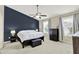 Relaxing main bedroom features a striking accent wall, ceiling fan, and plush carpeting at 3811 Tartan Trl, Whitestown, IN 46075