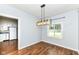 Cozy dining area featuring hardwood floors and a stylish light fixture next to the window at 402 E 4Th St, Sheridan, IN 46069
