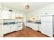 Functional kitchen with white cabinets, gas range, and wood-look flooring at 402 E 4Th St, Sheridan, IN 46069