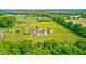 Gorgeous aerial showcasing a property with a luxurious pool, brick home, and meticulously mowed lawn at 4181 Whitetail Woods Dr, Bargersville, IN 46106