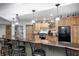 Basement bar with wooden cabinets, a black countertop, black stools and overhead lighting at 4181 Whitetail Woods Dr, Bargersville, IN 46106