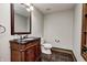 Powder room featuring a wooden vanity, dark granite countertop, and bronze hardware at 4181 Whitetail Woods Dr, Bargersville, IN 46106