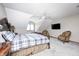 Bedroom features a decorative wood bedframe, ceiling fan, and charming sitting chairs at 4181 Whitetail Woods Dr, Bargersville, IN 46106