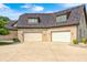 An exterior view showing a three-car garage of a brick home with concrete driveway and manicured landscaping at 4181 Whitetail Woods Dr, Bargersville, IN 46106