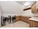 Laundry room with washer and dryer, tile flooring, wooden cabinets and counters, and overhead light at 4181 Whitetail Woods Dr, Bargersville, IN 46106