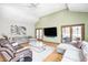 This airy living room has a ceiling fan, vaulted ceiling, doors to the back, and layered seating at 4181 Whitetail Woods Dr, Bargersville, IN 46106