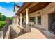 The covered patio features comfortable seating and offers a serene view of the landscaped yard at 4181 Whitetail Woods Dr, Bargersville, IN 46106