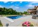 A stunning pool is set against a lush, tree-lined yard and a beautiful brick home, perfect for entertaining at 4181 Whitetail Woods Dr, Bargersville, IN 46106