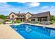A stunning pool reflecting the house, patio furniture, and a green, landscaped yard create a relaxing outdoor space at 4181 Whitetail Woods Dr, Bargersville, IN 46106