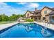 Enjoy the backyard oasis with a sparkling pool, complemented by the brick home and blue skies in the background at 4181 Whitetail Woods Dr, Bargersville, IN 46106