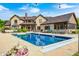 Beautiful in-ground pool with home exterior, outdoor seating, surrounded by a patio and green landscape at 4181 Whitetail Woods Dr, Bargersville, IN 46106