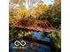 Picturesque red bridge over a stream with reflections in the water, surrounded by greenery at 4295 Hamilton Run, Zionsville, IN 46077