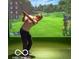 Personal using indoor golf simulator, with a realistic golf course view displayed on screen at 4295 Hamilton Run, Zionsville, IN 46077