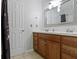 Bathroom featuring a double sink vanity with wood cabinets and a large mirror at 4718 Dancer Dr, Indianapolis, IN 46237