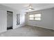 Bright bedroom with neutral walls, ceiling fan, window, and mirrored decoration at 4718 Dancer Dr, Indianapolis, IN 46237