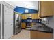 An updated kitchen with stainless steel appliances, tile floors, and a blue accent wall at 4718 Dancer Dr, Indianapolis, IN 46237