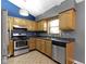 A kitchen with light wood cabinets, tile floors, and stainless steel appliances at 4718 Dancer Dr, Indianapolis, IN 46237