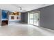 Open living room with tile flooring, sliding glass door, and view of upper-level kitchen at 4718 Dancer Dr, Indianapolis, IN 46237
