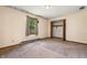 Bedroom features a large window with natural light, neutral carpet, and a closet with the doors open at 5380 Collett E Dr, Camby, IN 46113