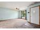 Bright living room with carpeted flooring and a front door with screen, freshly painted walls, and ceiling fan at 5380 Collett E Dr, Camby, IN 46113