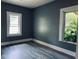 A clean and bright bedroom space featuring neutral walls and wood-look floors, illuminated by two windows at 547 N Livingston Ave, Indianapolis, IN 46222