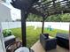 Backyard showcasing a pergola-covered patio with outdoor seating, a white fence, and green lawn at 5702 Deer Valley Ct, Columbus, IN 47201