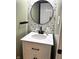 Powder room with single white vanity, decorative mirror, and stylish floral wallpaper at 5702 Deer Valley Ct, Columbus, IN 47201