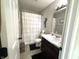 Well-lit bathroom featuring a vanity with a sink, toilet, and a shower with a white ruffled curtain at 5702 Deer Valley Ct, Columbus, IN 47201