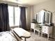 Bright bedroom featuring a vanity with a tri-fold mirror, complemented by neutral walls and plush carpeting at 5702 Deer Valley Ct, Columbus, IN 47201