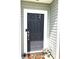 Close-up of the front door with a Hello mat and potted flowers, creating a welcoming entrance at 5702 Deer Valley Ct, Columbus, IN 47201