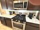Close-up of the kitchen features stainless steel oven/range with granite countertops and dark wood cabinetry at 5702 Deer Valley Ct, Columbus, IN 47201
