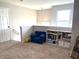 Upstairs landing area with carpet, blue chair, shelving, and window at 5702 Deer Valley Ct, Columbus, IN 47201