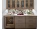 Chic bar area with a wine refrigerator, stylish cabinets, and unique backsplash at 5946 Stafford Way, Indianapolis, IN 46228