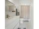 Modern bathroom with white fixtures, stylish mirror, and a shower with patterned curtain at 5946 Stafford Way, Indianapolis, IN 46228