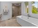 Modern bathroom with a soaking tub, walk-in shower, and natural light at 5946 Stafford Way, Indianapolis, IN 46228