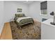 Calm bedroom with patterned bedding, hardwood floors, and a desk near the window at 5946 Stafford Way, Indianapolis, IN 46228