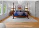 Serene bedroom with a four-poster bed, hardwood floors, and ample natural light at 5946 Stafford Way, Indianapolis, IN 46228