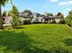 Expansive lawn and a partial view of a modern two-story white brick home with a black roof at 5946 Stafford Way, Indianapolis, IN 46228