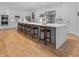 Bright kitchen featuring a large island with barstool seating and hardwood floors at 5946 Stafford Way, Indianapolis, IN 46228
