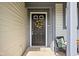 Close up of the main front door with a floral wreath and outdoor seating at 5966 Draycott Dr, Indianapolis, IN 46236