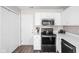 White kitchen featuring stainless steel microwave and range, with modern countertops at 5966 Draycott Dr, Indianapolis, IN 46236