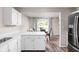 Open kitchen with a dining area, white cabinets, and stainless steel refrigerator at 5966 Draycott Dr, Indianapolis, IN 46236