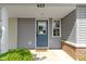 A covered front door with a storm door, brick accents and landscape at 603 Daviess Dr, Westfield, IN 46074