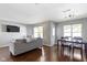 Open-concept living area with a sofa, television, hardwood flooring and dining table next to bright windows at 603 Daviess Dr, Westfield, IN 46074