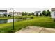 Landscaped backyard featuring a pond with community homes in the distance at 6114 Pebblebrooke Rd, Whitestown, IN 46075