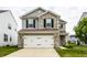 Charming two-story home featuring stone accents, a gray siding, and a two-car garage at 6114 Pebblebrooke Rd, Whitestown, IN 46075
