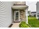 Close-up of the front door with stone accents and lush landscaping at 6114 Pebblebrooke Rd, Whitestown, IN 46075