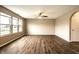 Spacious living room with hardwood floors, ceiling fan, and three windows at 6114 Pebblebrooke Rd, Whitestown, IN 46075